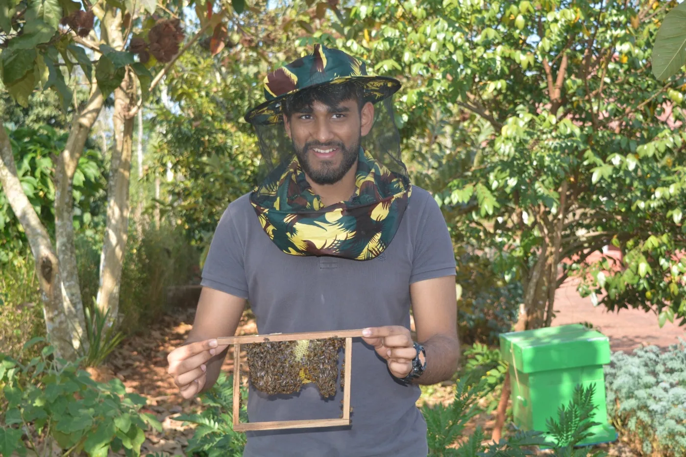 A beekeeper on the estate holding up a frame of wild honeycomb